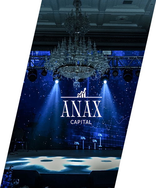 Anax Capital corporate event stage with a branded LED screen, elegant crystal chandelier and professional blue stage lighting in a grand ballroom